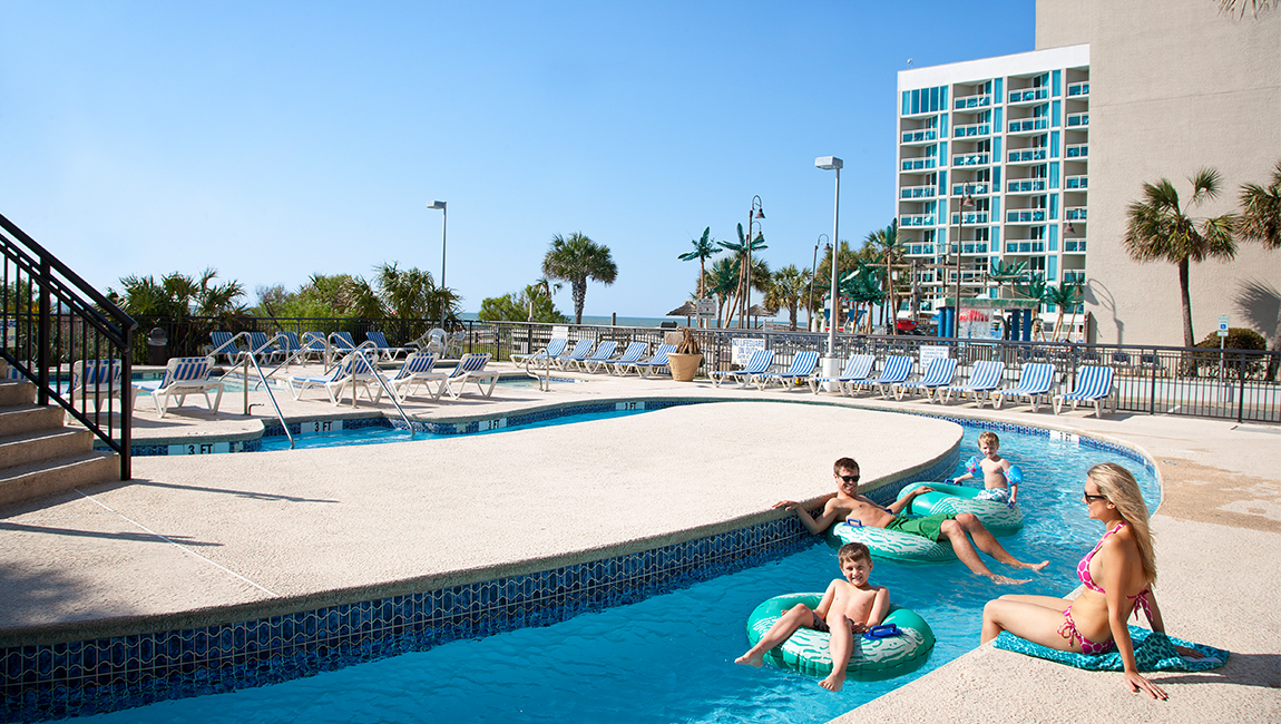 A family of four enjoys the pool on a sunny day.